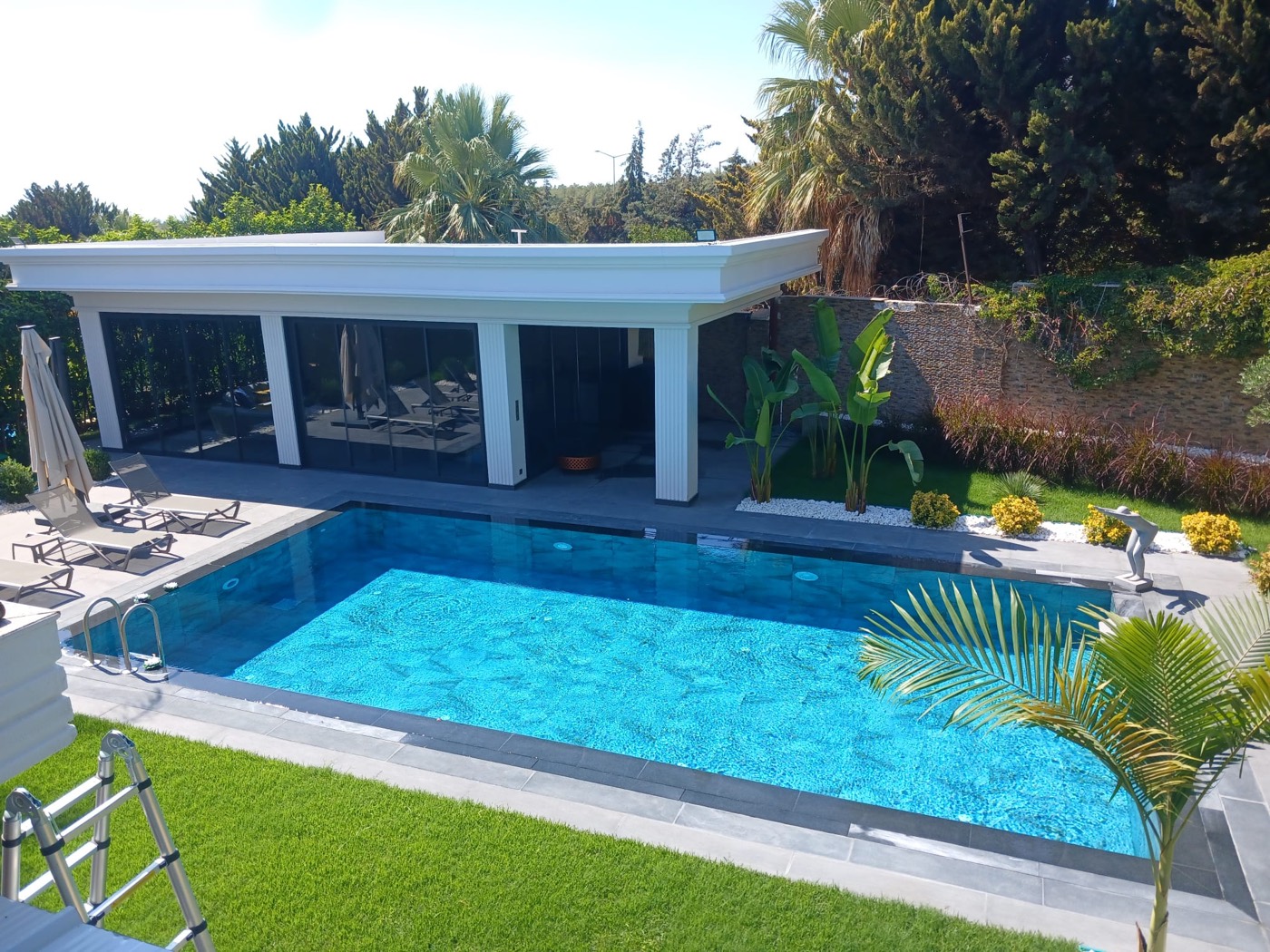Villa bahçesinde çelik pergola ve havuz